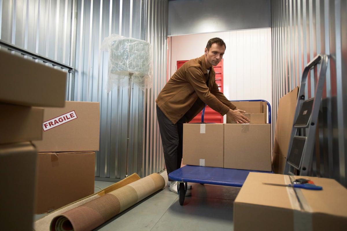 Man sorting cardboard boxes inside a storage unit
